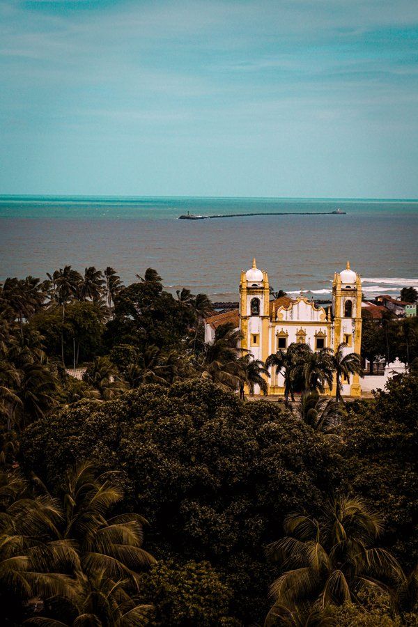 Igreja do Carmo in Olinda An aerial view of a church surrounded by trees and a body of water.