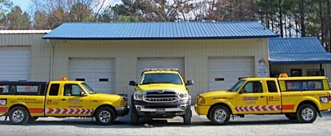 Three yellow trucks are parked in front of a building