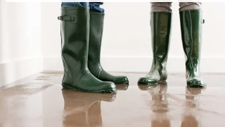 A person 's feet are hanging over a waterfall in a dark room.