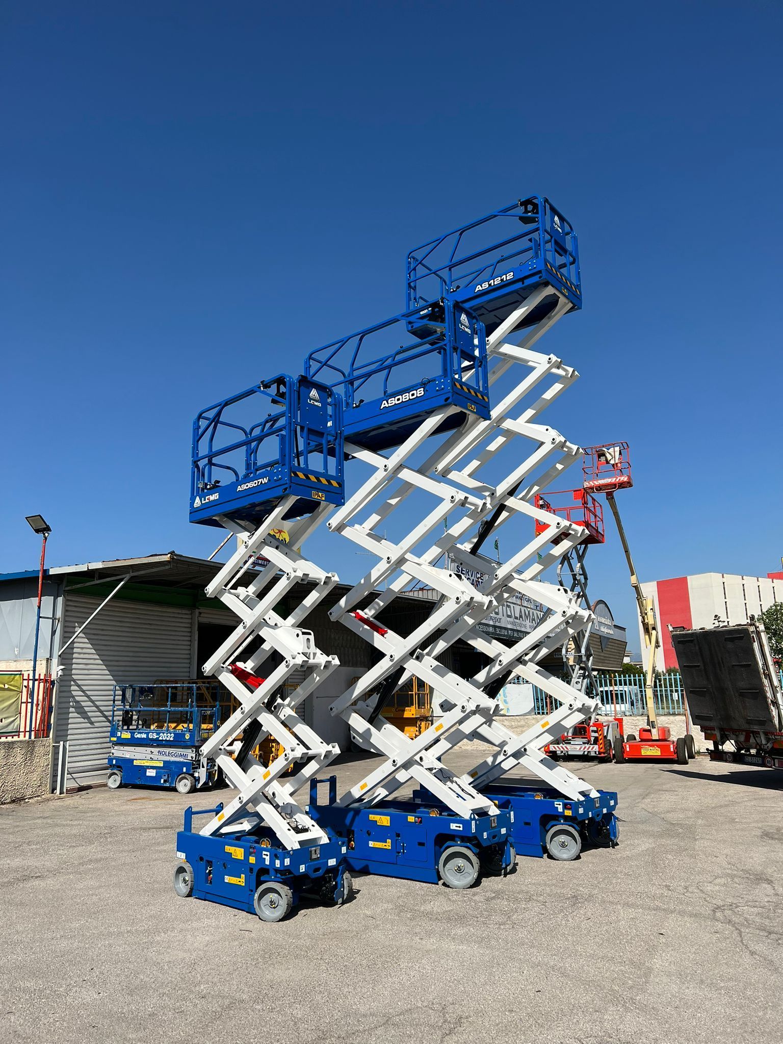 Tre piattaforme aeree blu e bianche all'aperto, contro un cielo azzurro terso.
