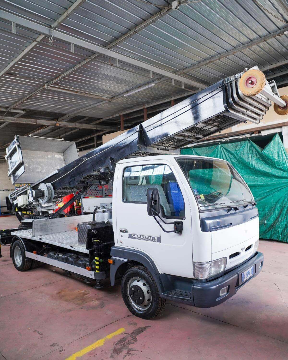 Camion bianco con piattaforma elevatrice in un magazzino.