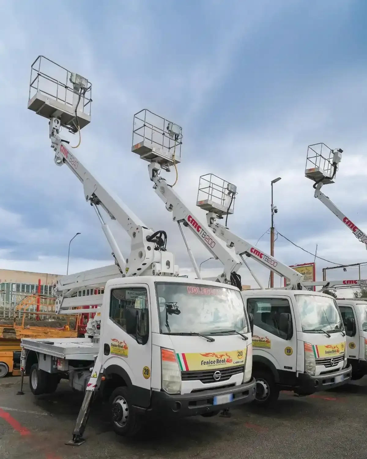 Carrelli elevatori bianchi con piattaforme rialzate, parcheggiati all'aperto.