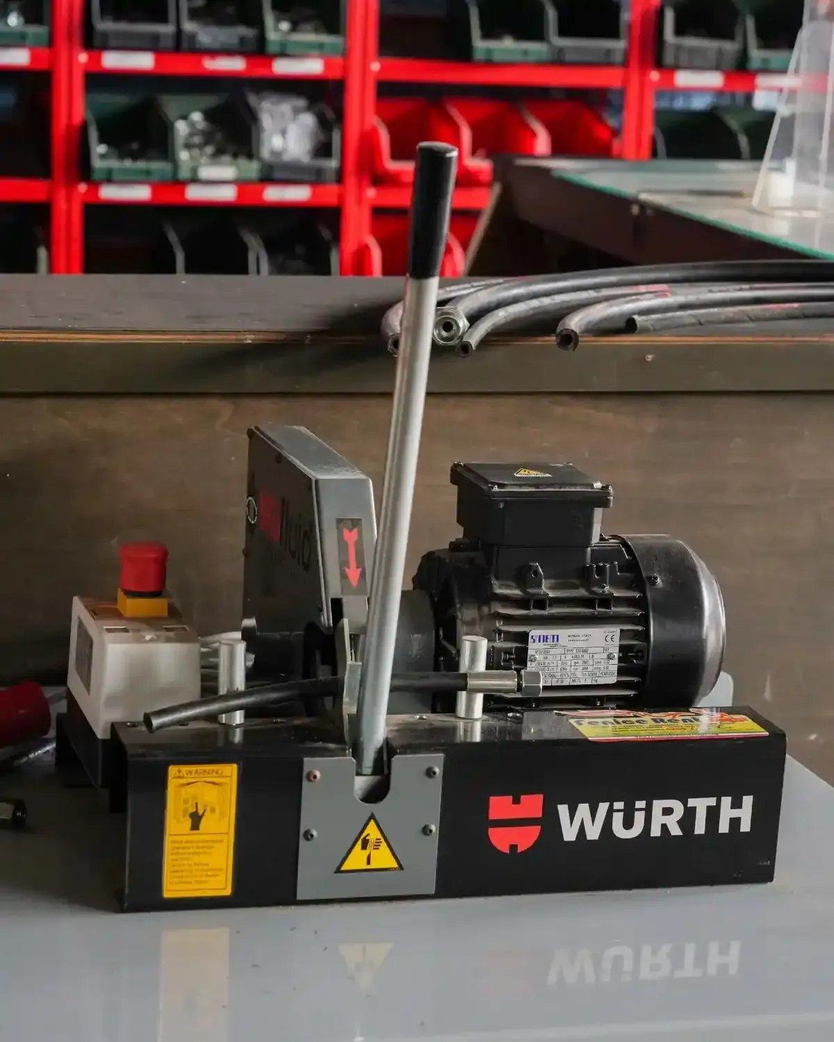Tagliatubi idraulici WURTH nero e grigio su un banco da lavoro, con pulsante di arresto rosso e motore.