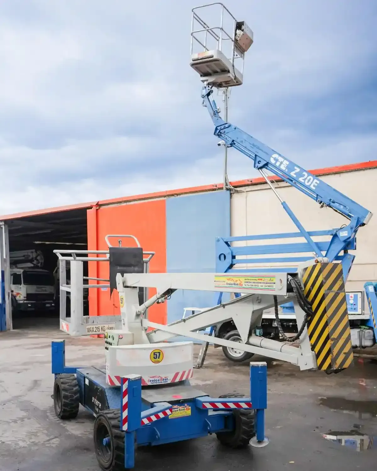 Piattaforma aerea CTE Z 20E blu e bianca estesa, parcheggiata di fronte a un edificio.