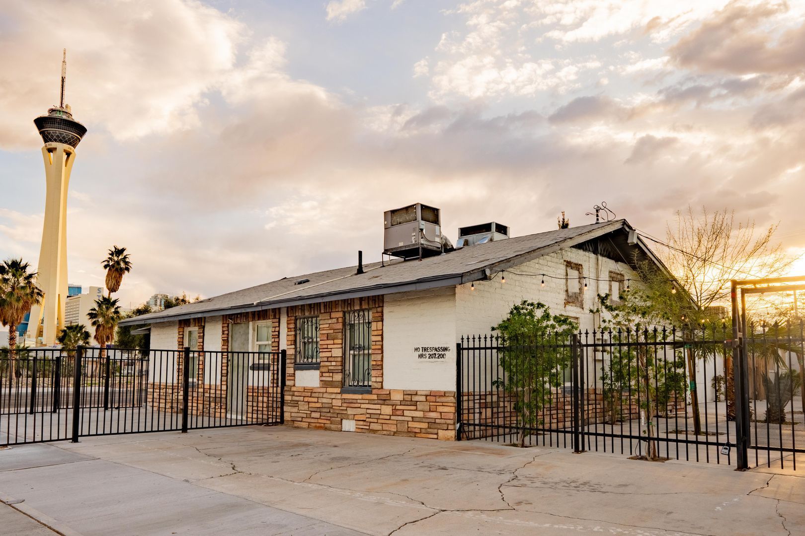 A house with a fence and a tower in the background