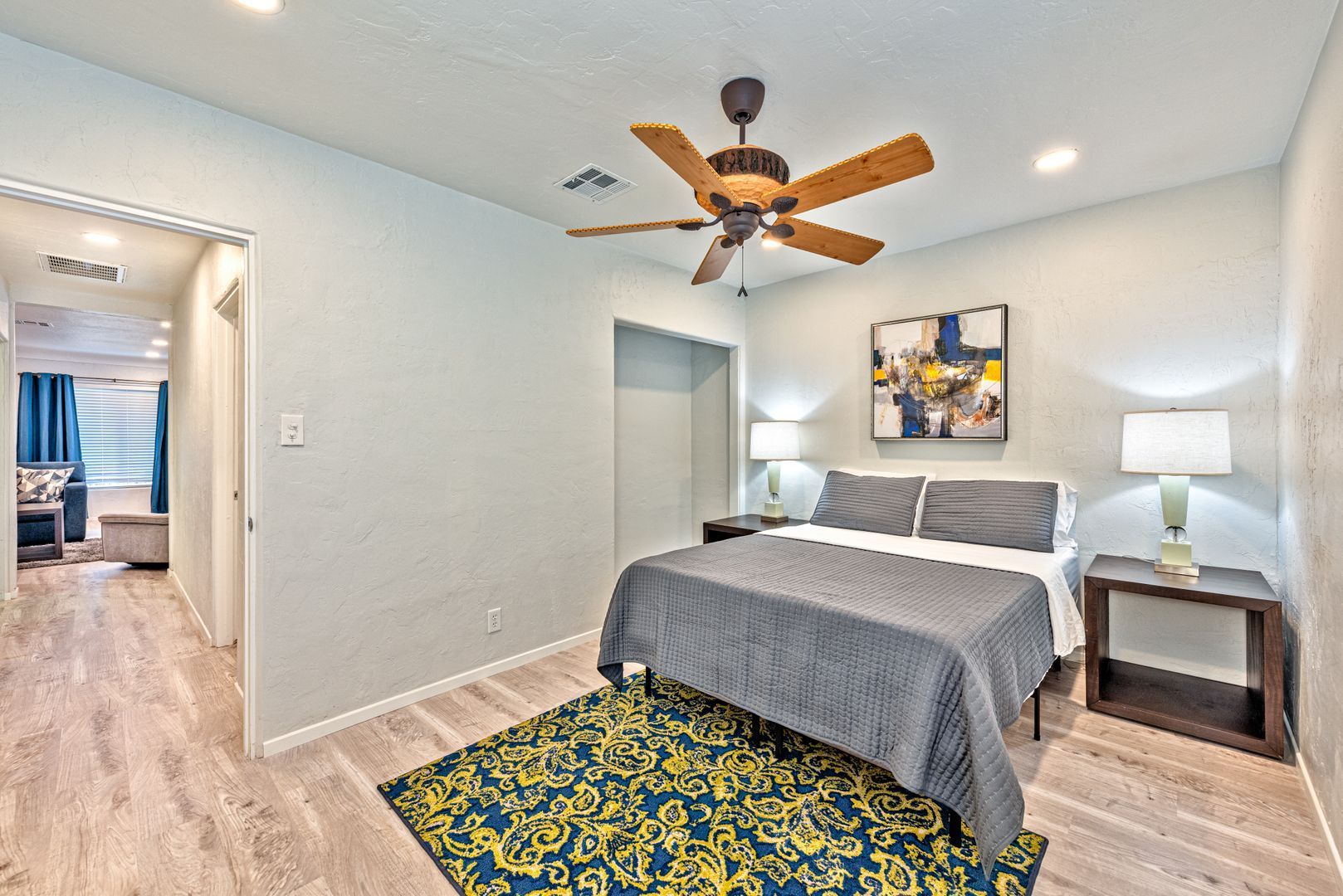A bedroom with a large bed and a ceiling fan.
