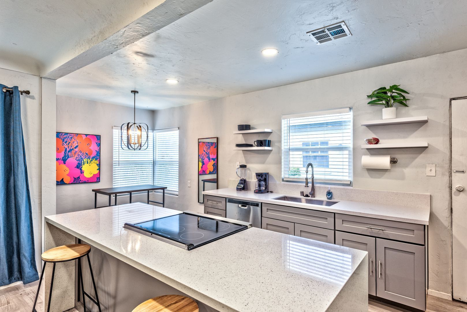 A kitchen with a large island , sink , and stove top oven.