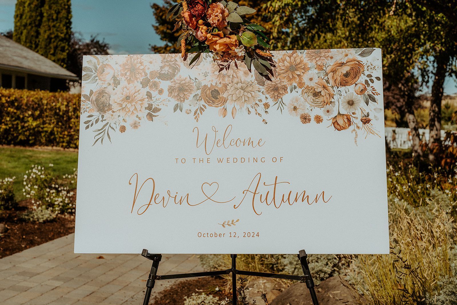 A welcome sign is sitting on top of an easel in a garden for a wedding in Southern Oregon.