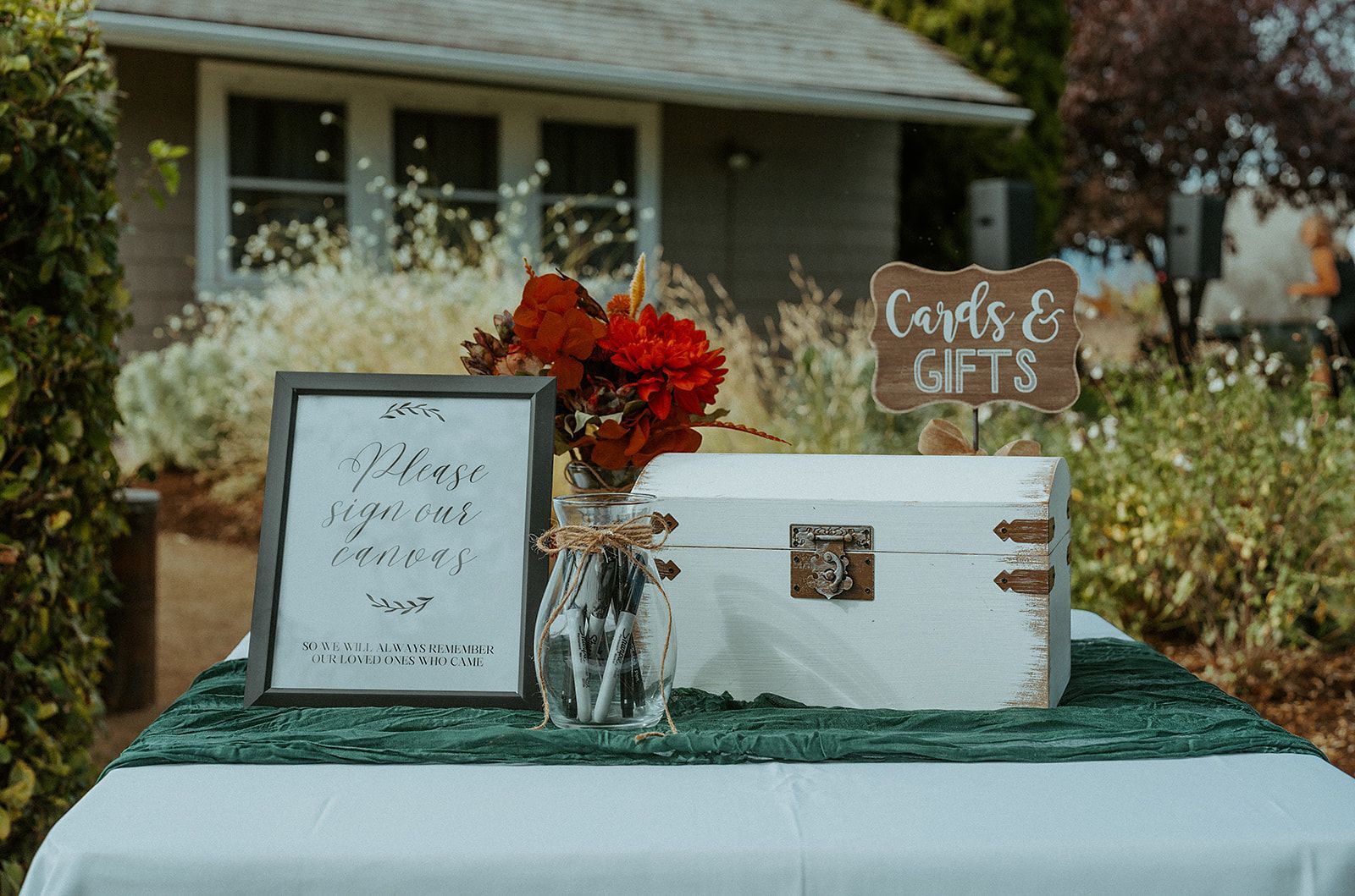 A table with a sign and a box on it in front of a house.