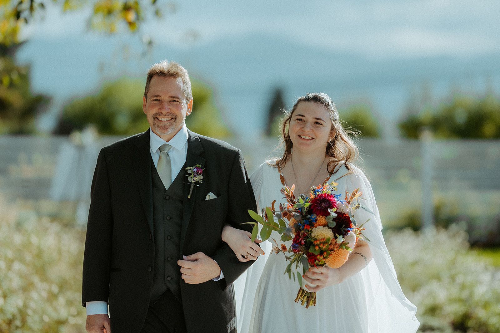 A bride and her father are walking down the aisle at their wedding.