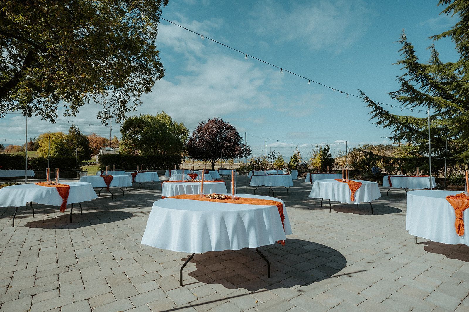 A patio with tables and chairs set up for a wedding party.