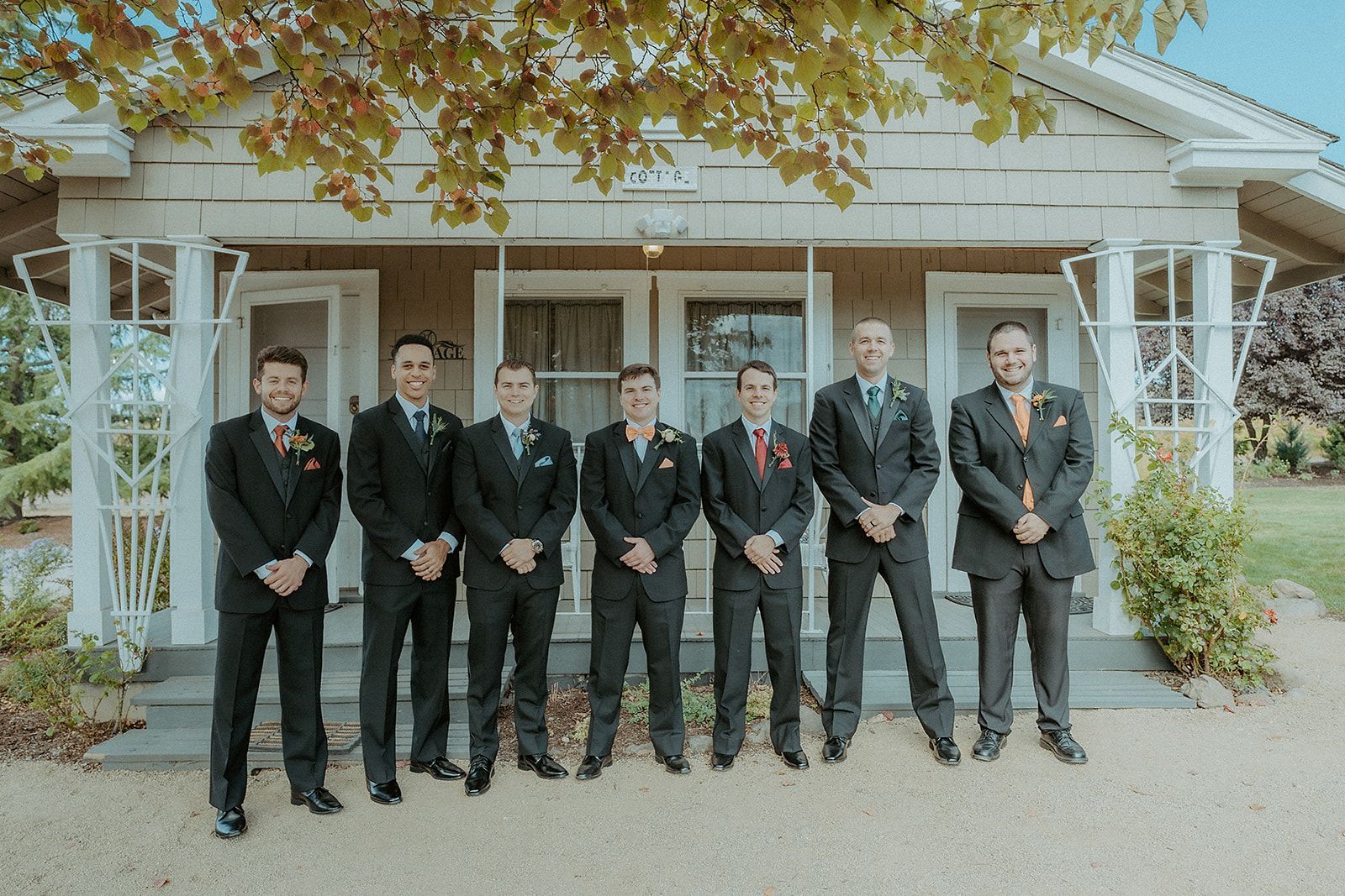 A group of men in suits are standing in front of a house.