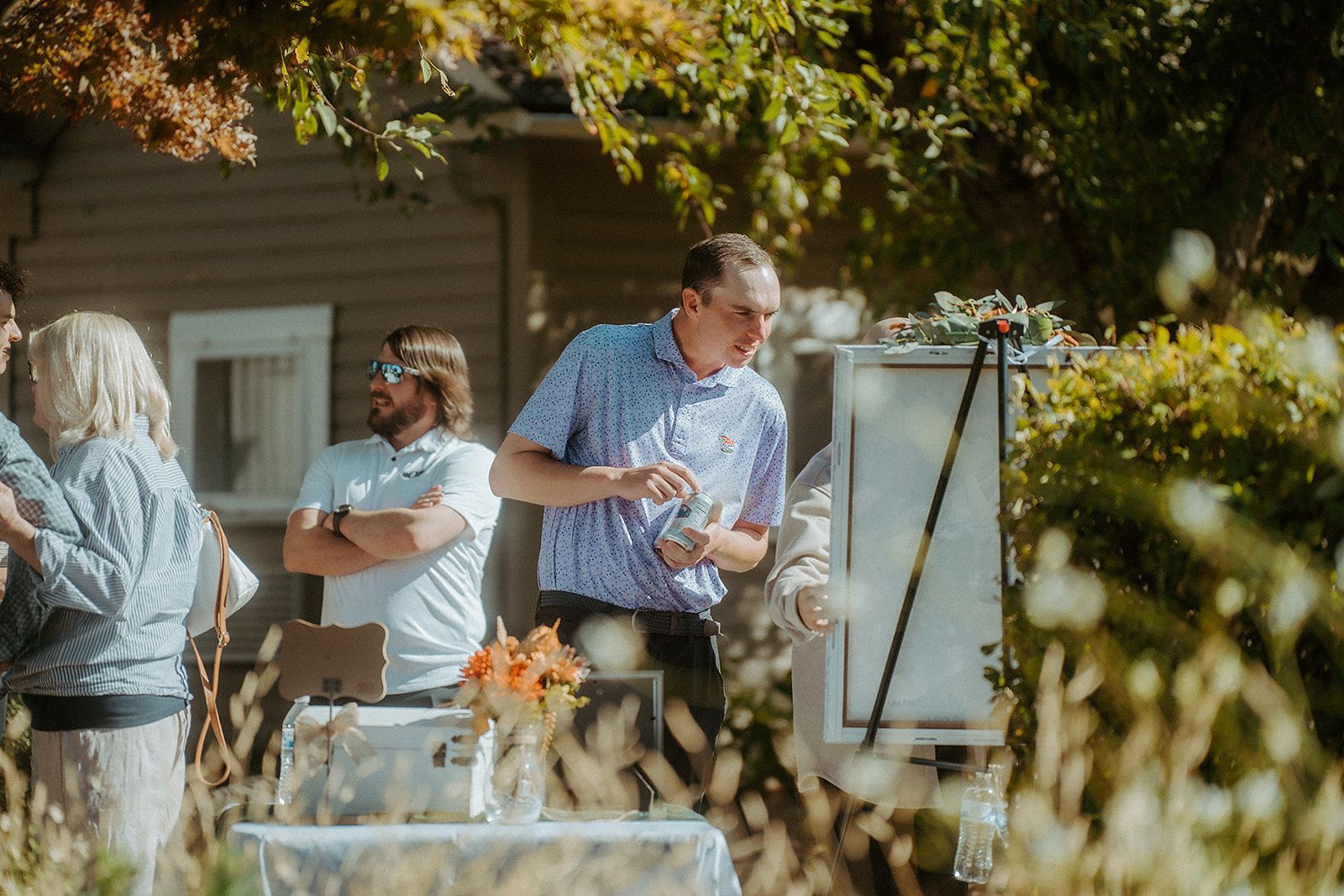 A group of people are standing outside of a house talking to each other.