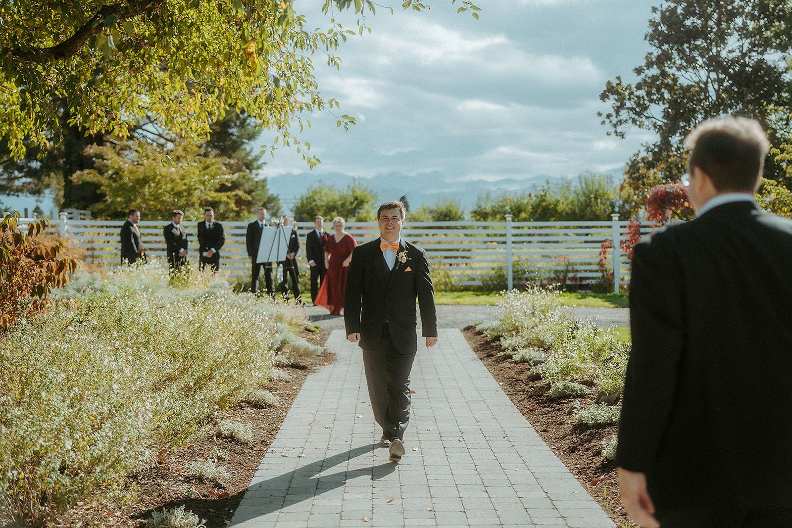 A groom is walking down the aisle at their wedding.