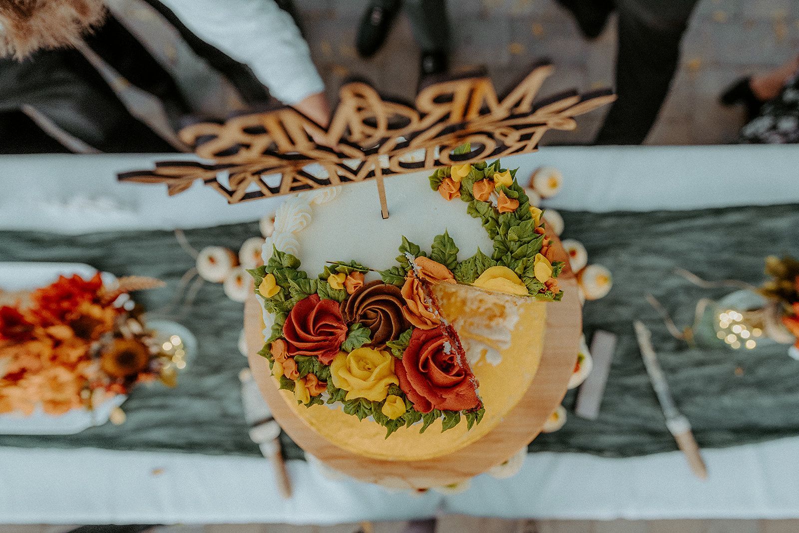 A wedding cake with flowers on it is sitting on a table.