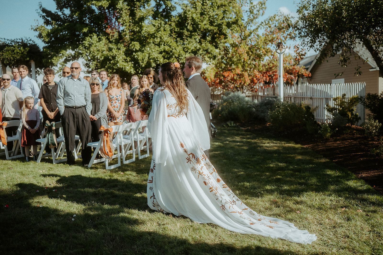 A bride and her father are walking down the aisle at their wedding.