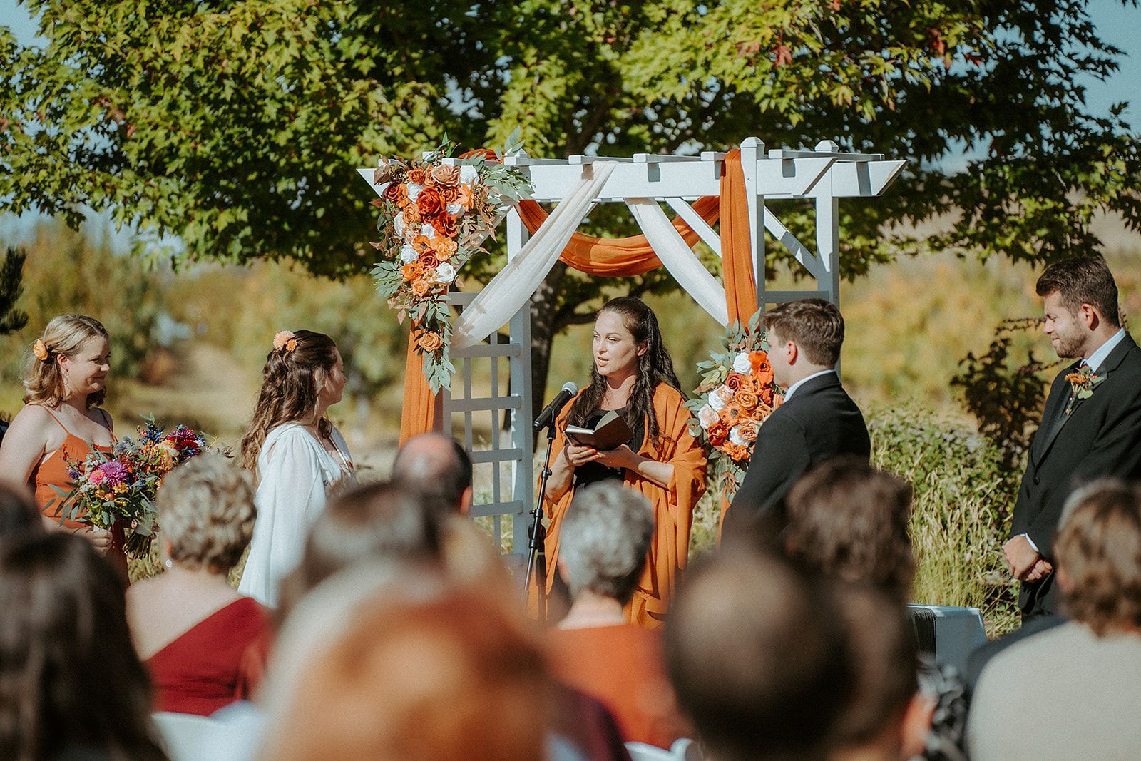 A bride and groom are getting married in front of a crowd of people at a wedding ceremony.