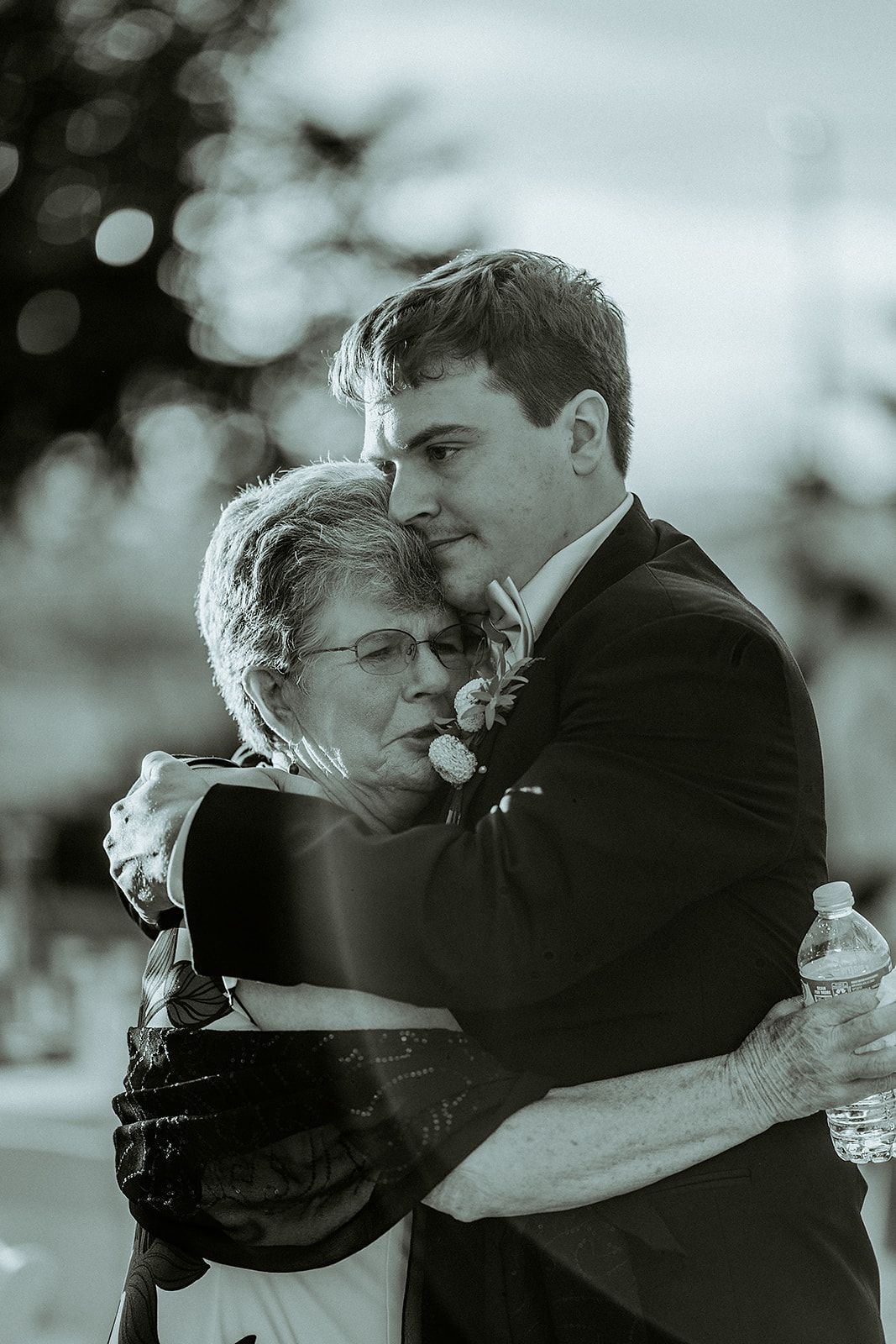 A man in a suit is hugging a woman in a black and white photo.