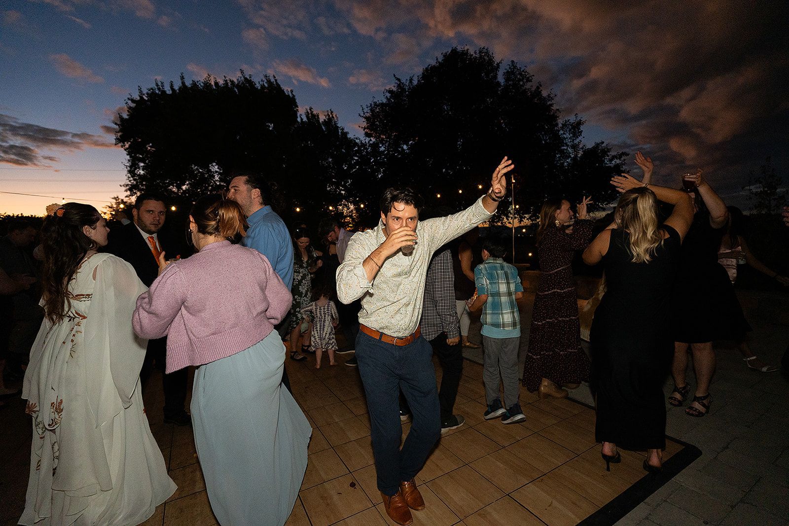 A group of people are dancing at a wedding reception.