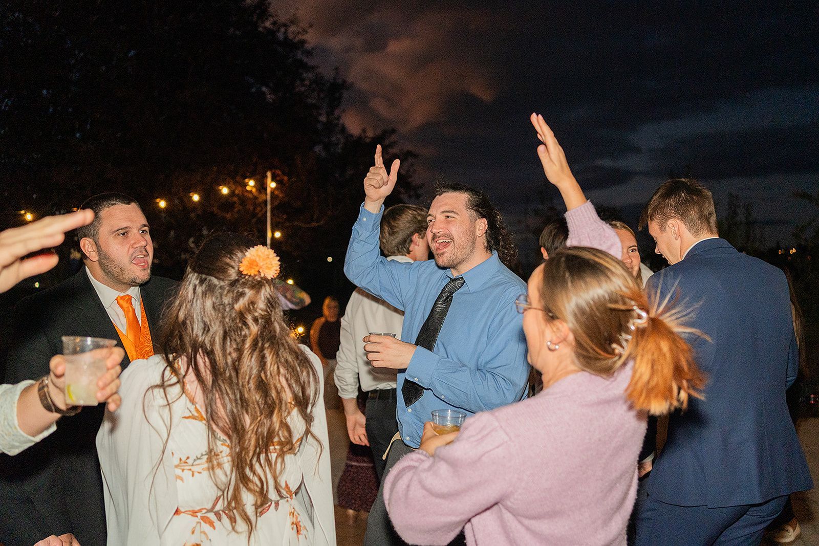 A group of people are dancing at a wedding reception.