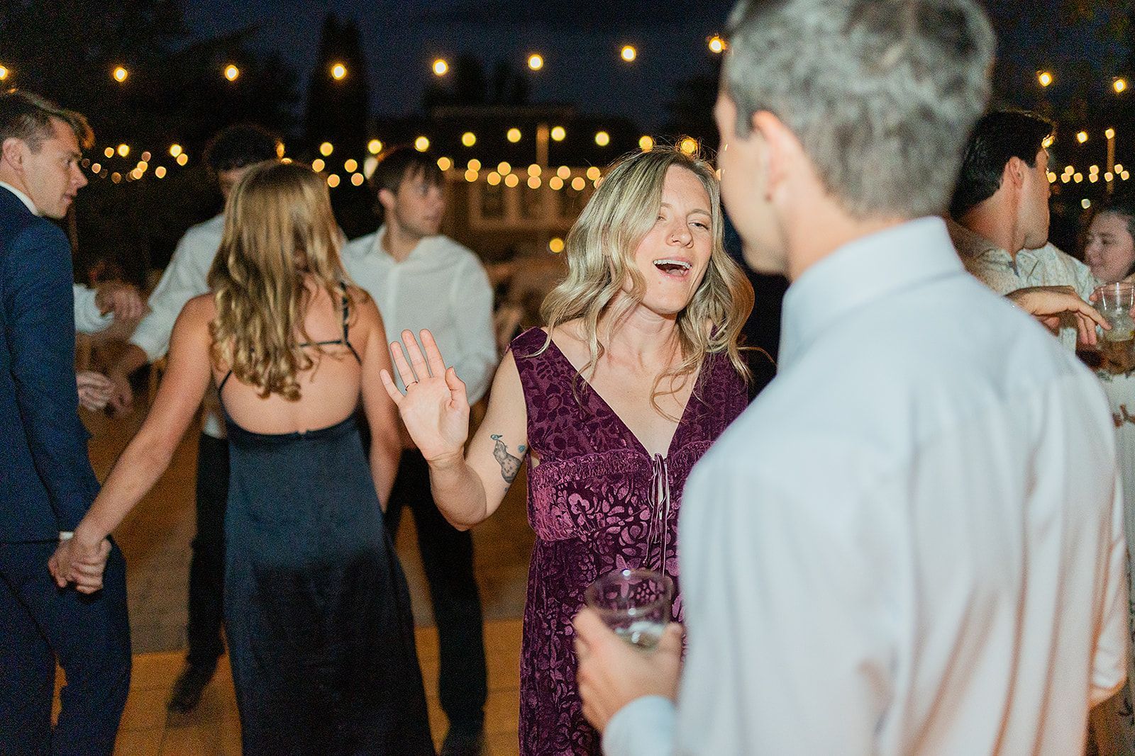 A group of people are dancing at a wedding reception.