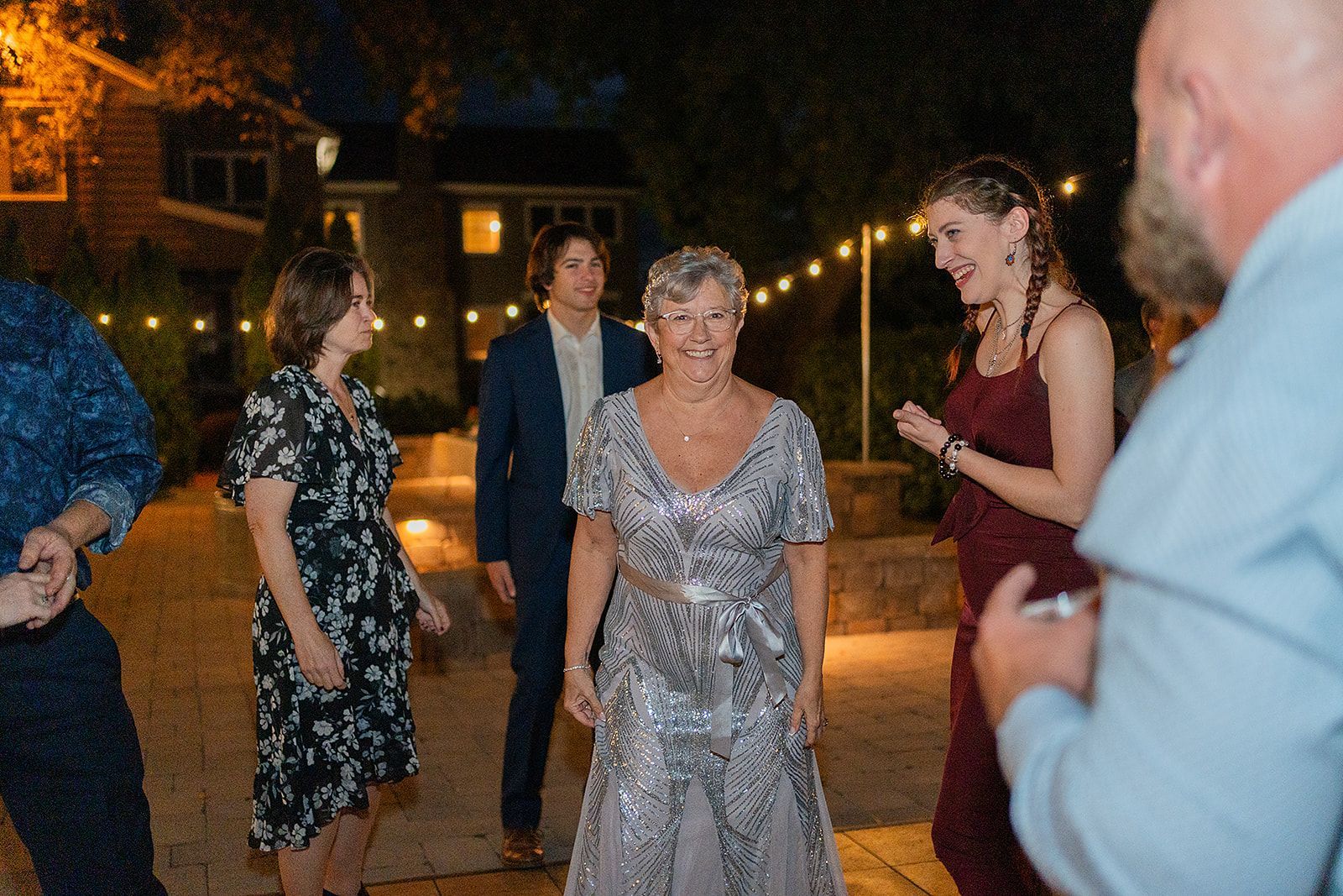 A group of people are dancing at a wedding reception.
