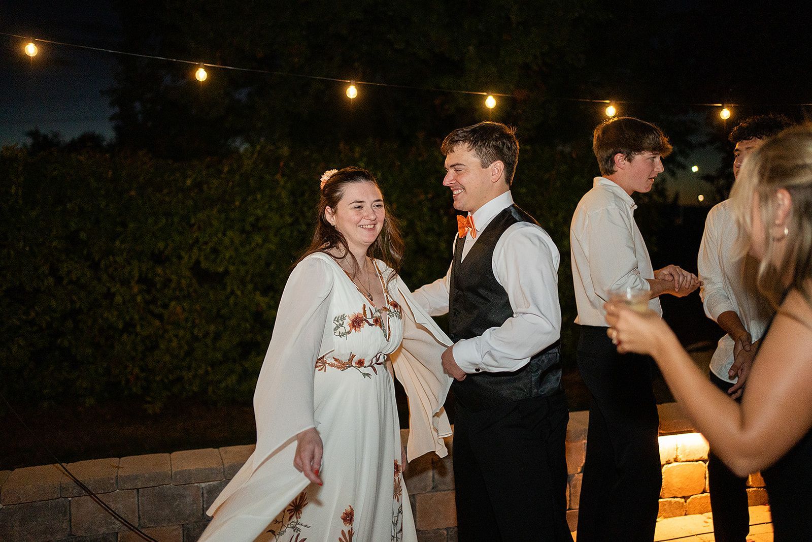 A group of people are dancing at a wedding reception.