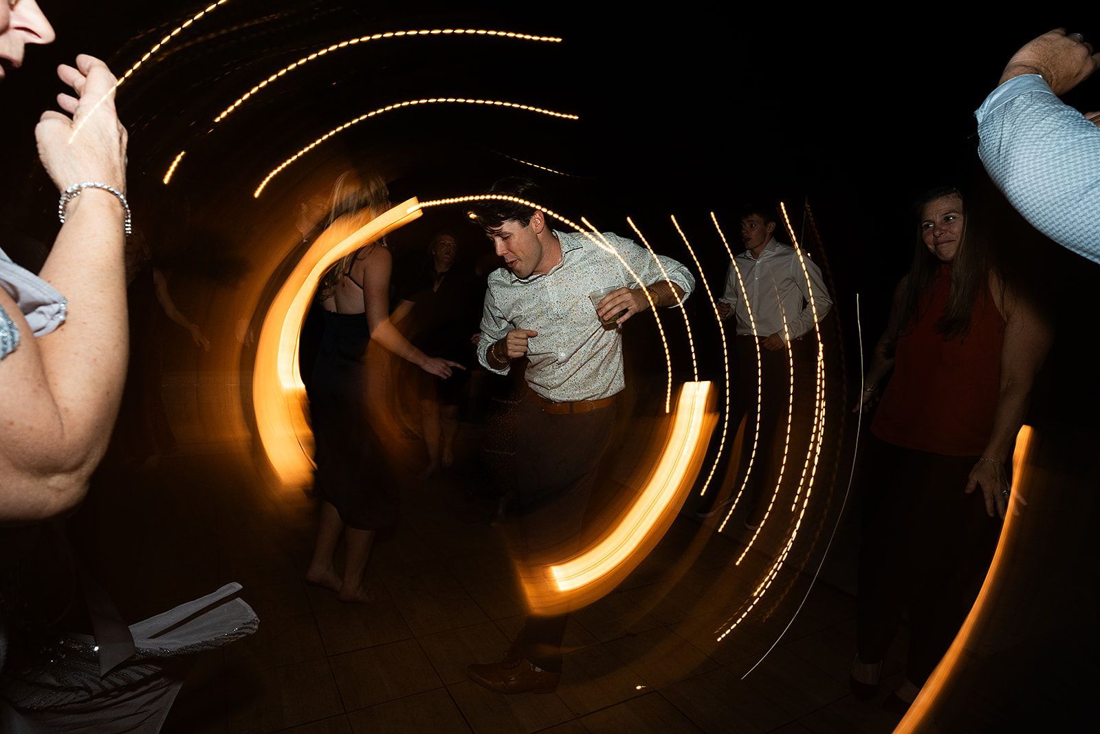 A group of people are dancing in a dark room.