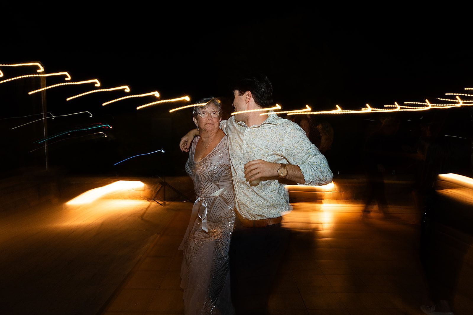 A blurry picture of a man and woman dancing at a wedding reception.