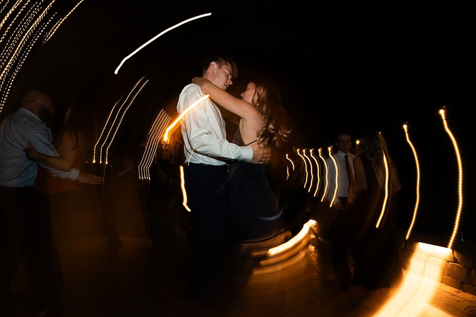 A blurry picture of a bride and groom dancing at a wedding reception.