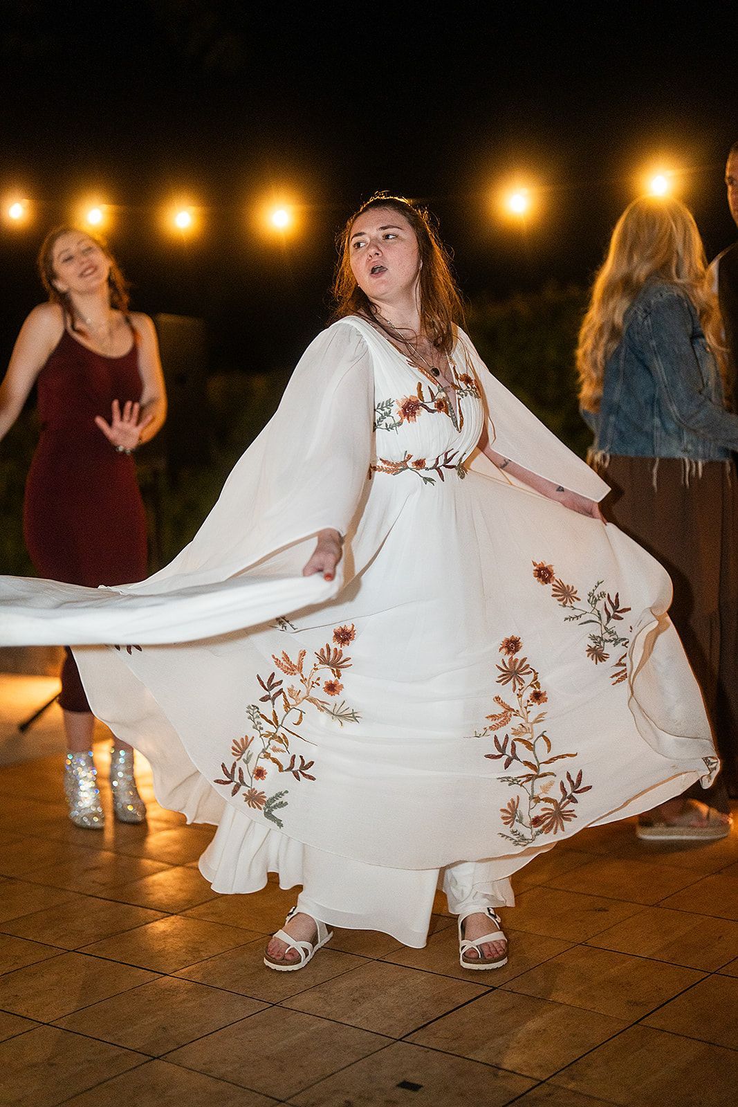 A bride in her wedding dress is dancing in front of a group of people.
