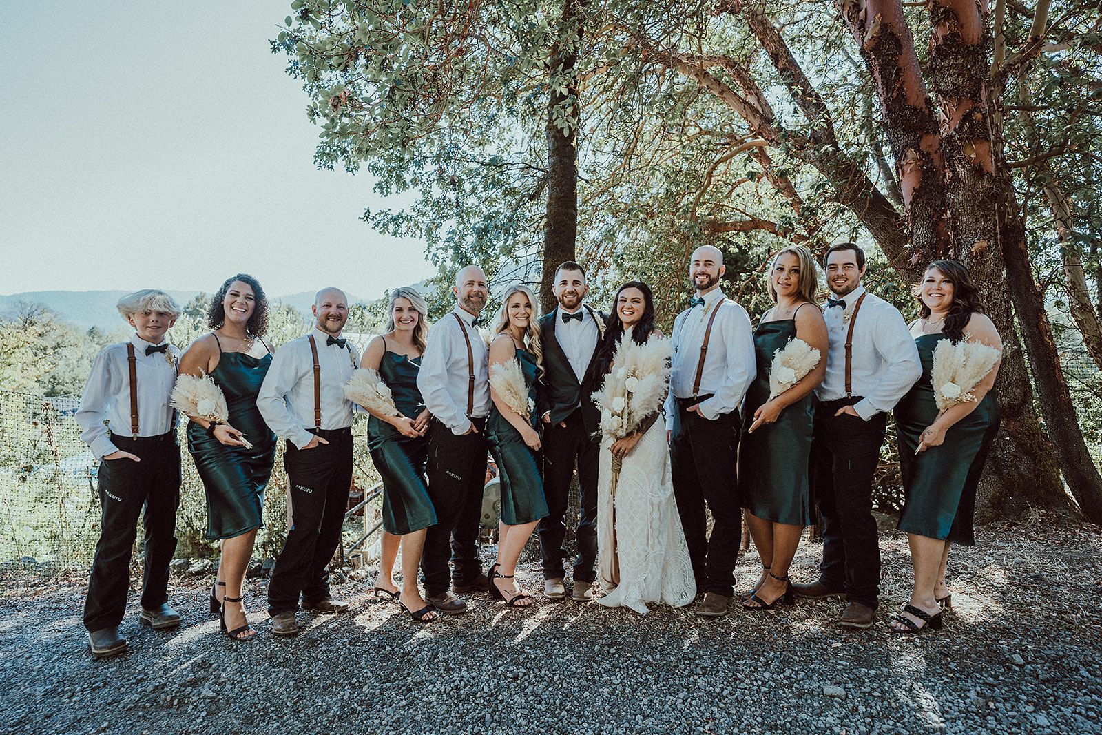 The bride and groom are posing for a picture with their wedding party.