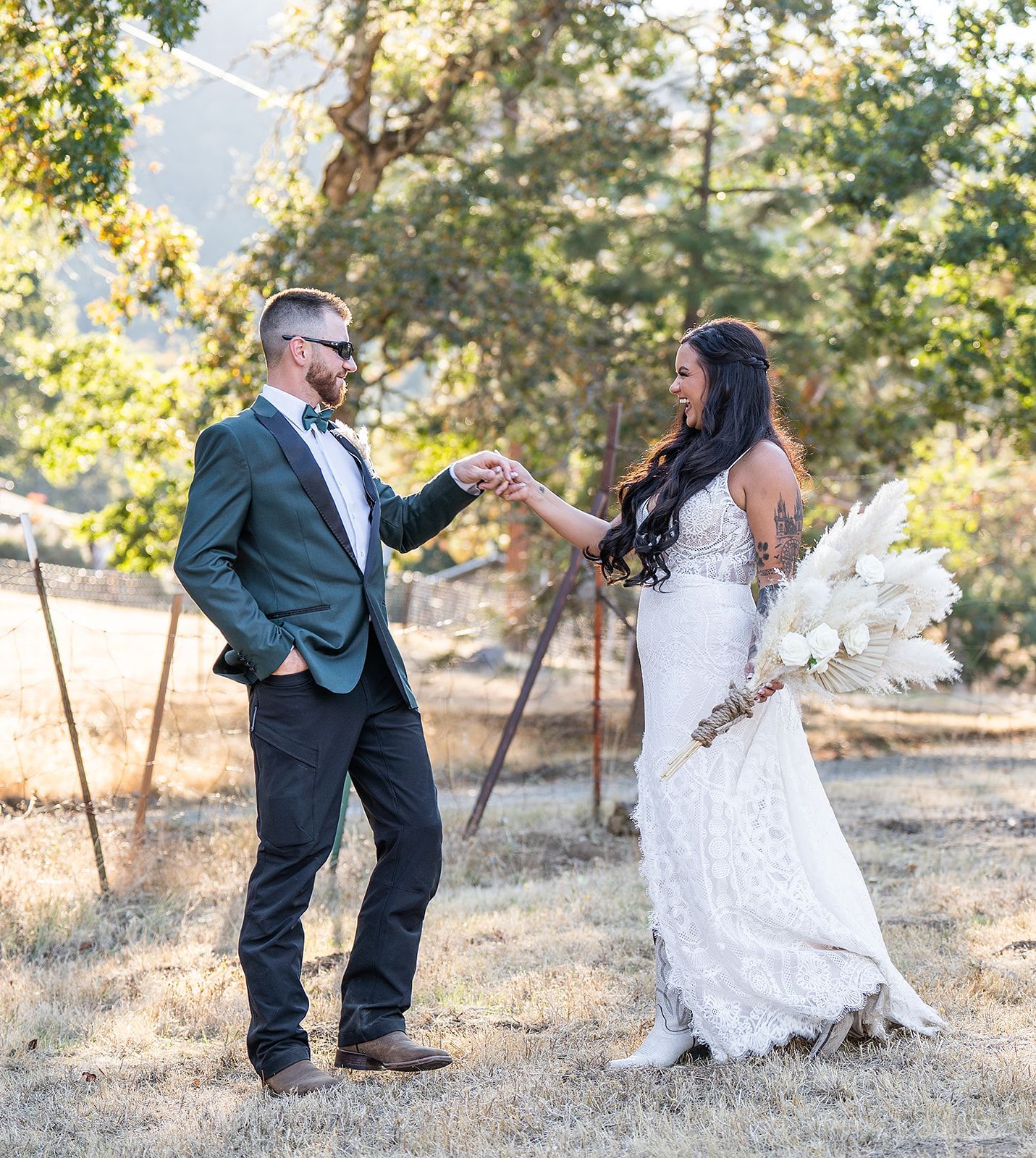A bride and groom are holding hands in a field.