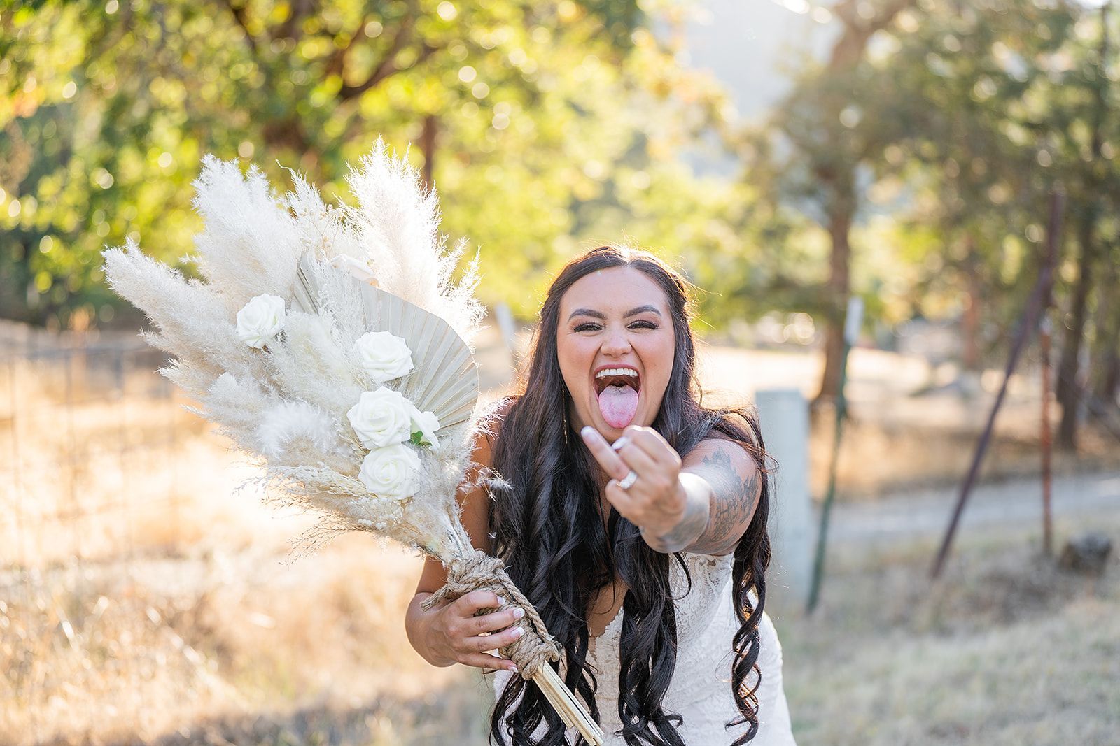 A woman in a white dress is holding a bouquet of flowers and sticking her tongue out.