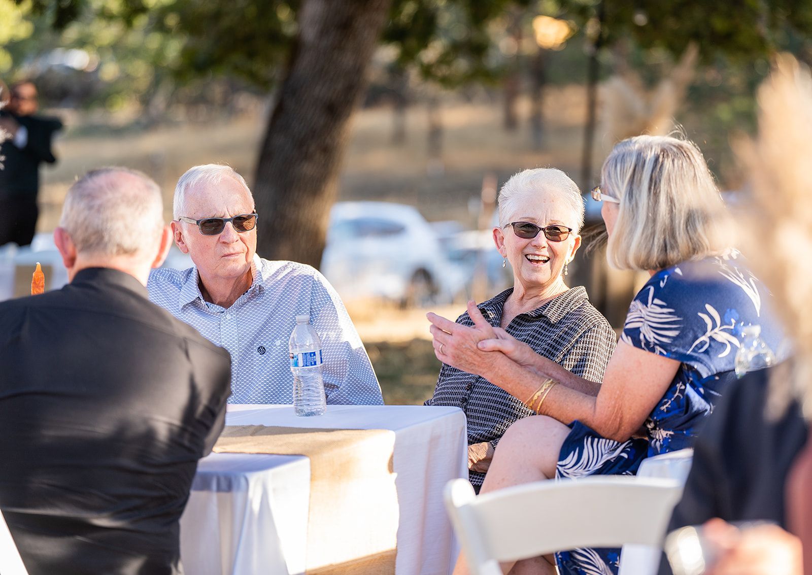 A group of people are sitting at a table talking to each other.