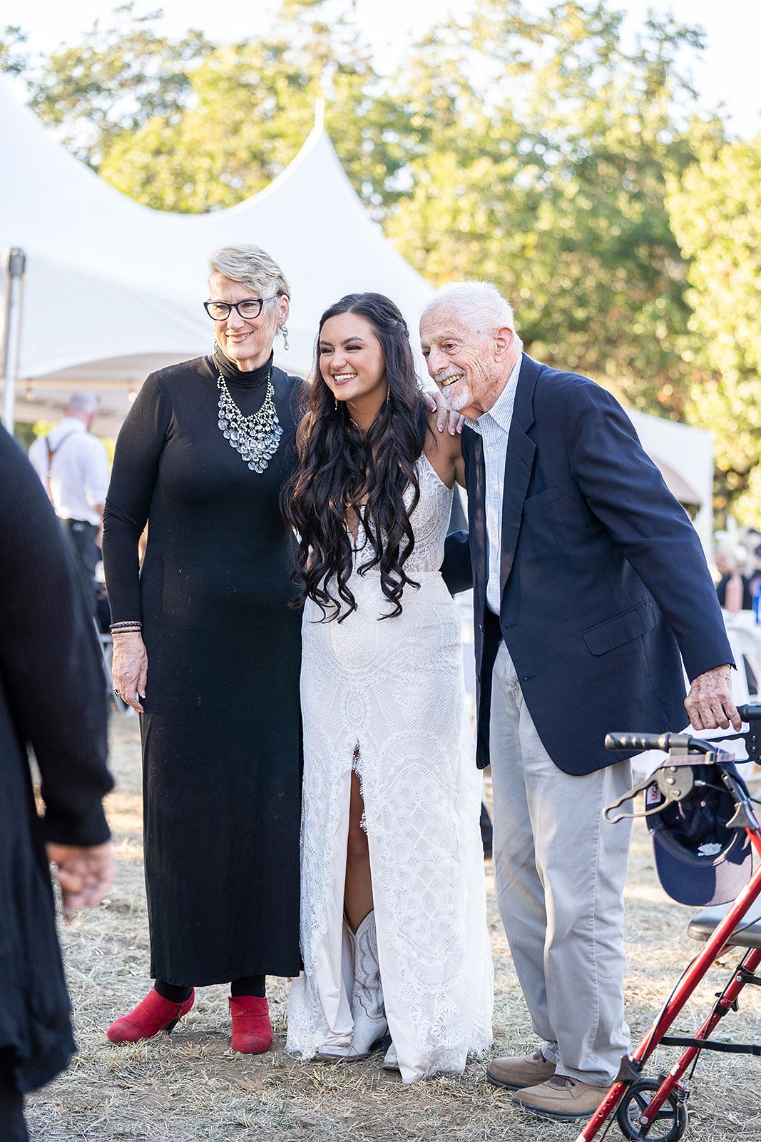 A bride and groom are posing for a picture with their parents.