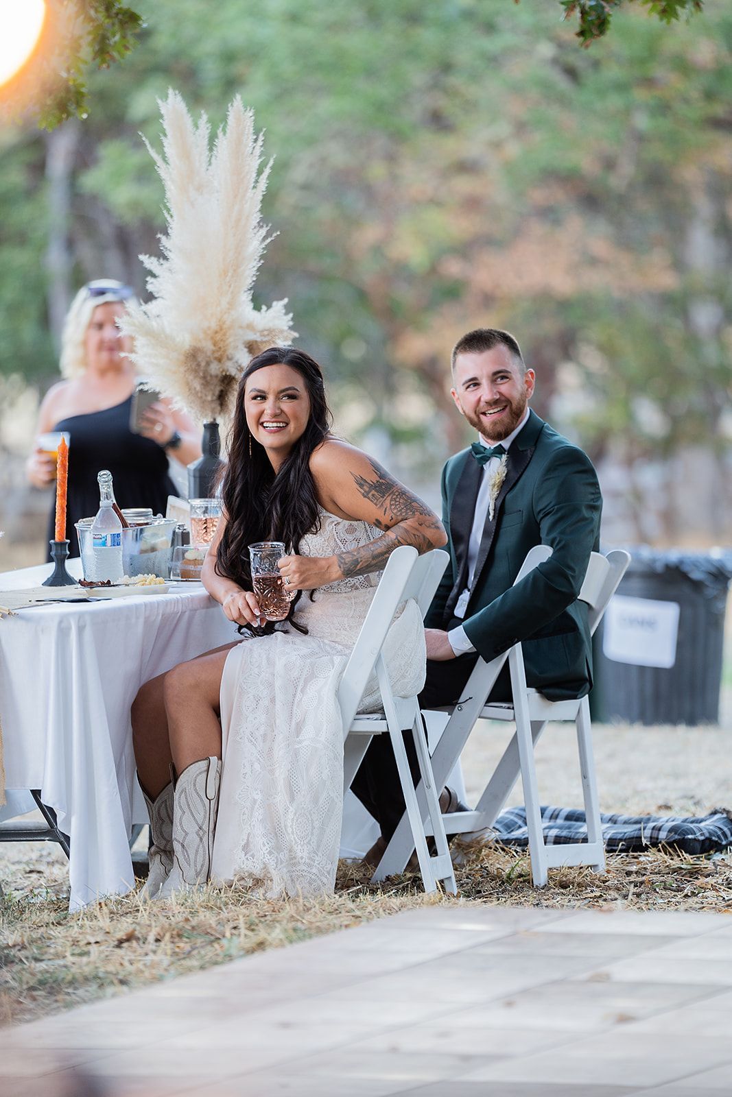 A bride and groom are sitting at a table at their wedding reception.