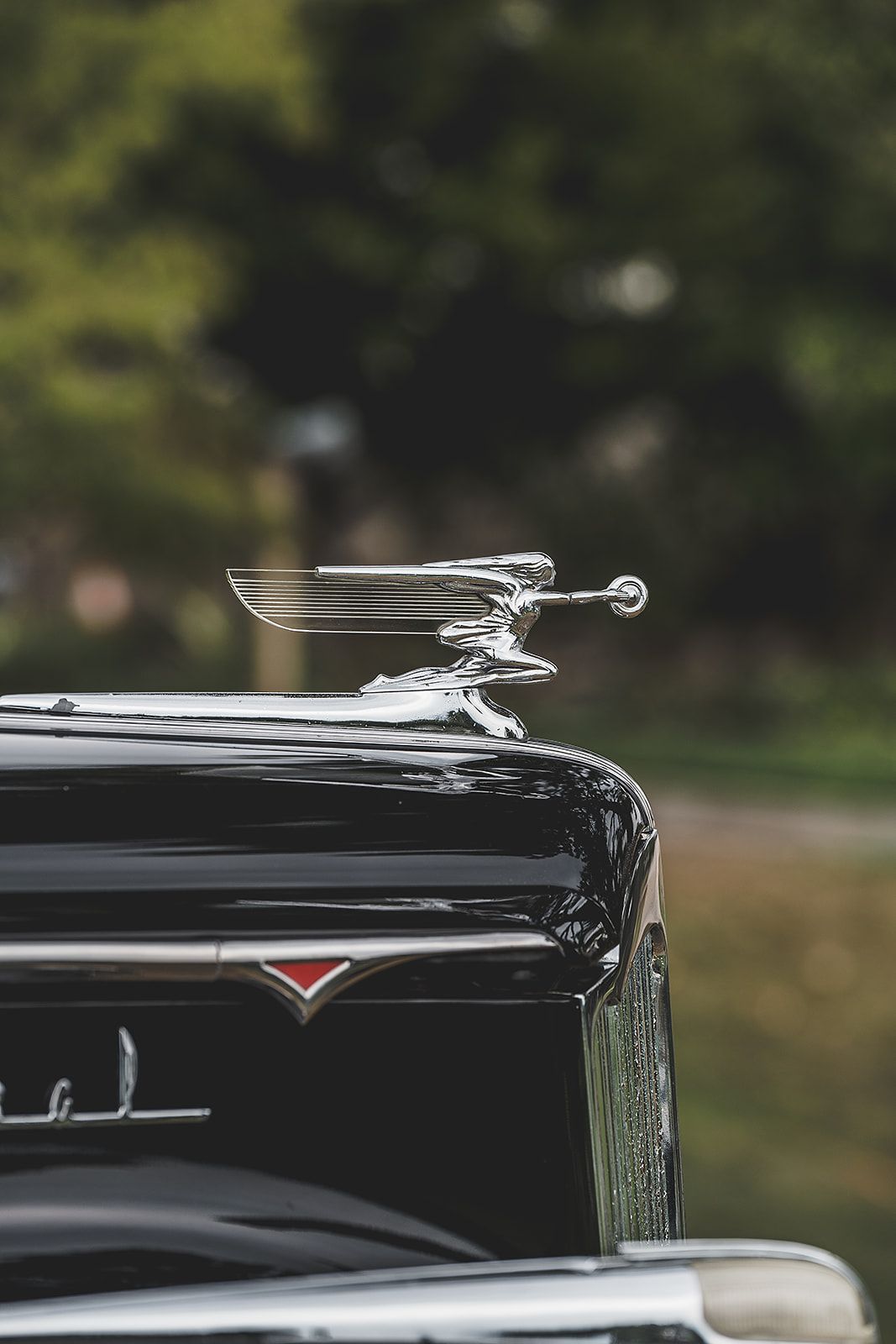 A close up of a car with a hood ornament on top of it.