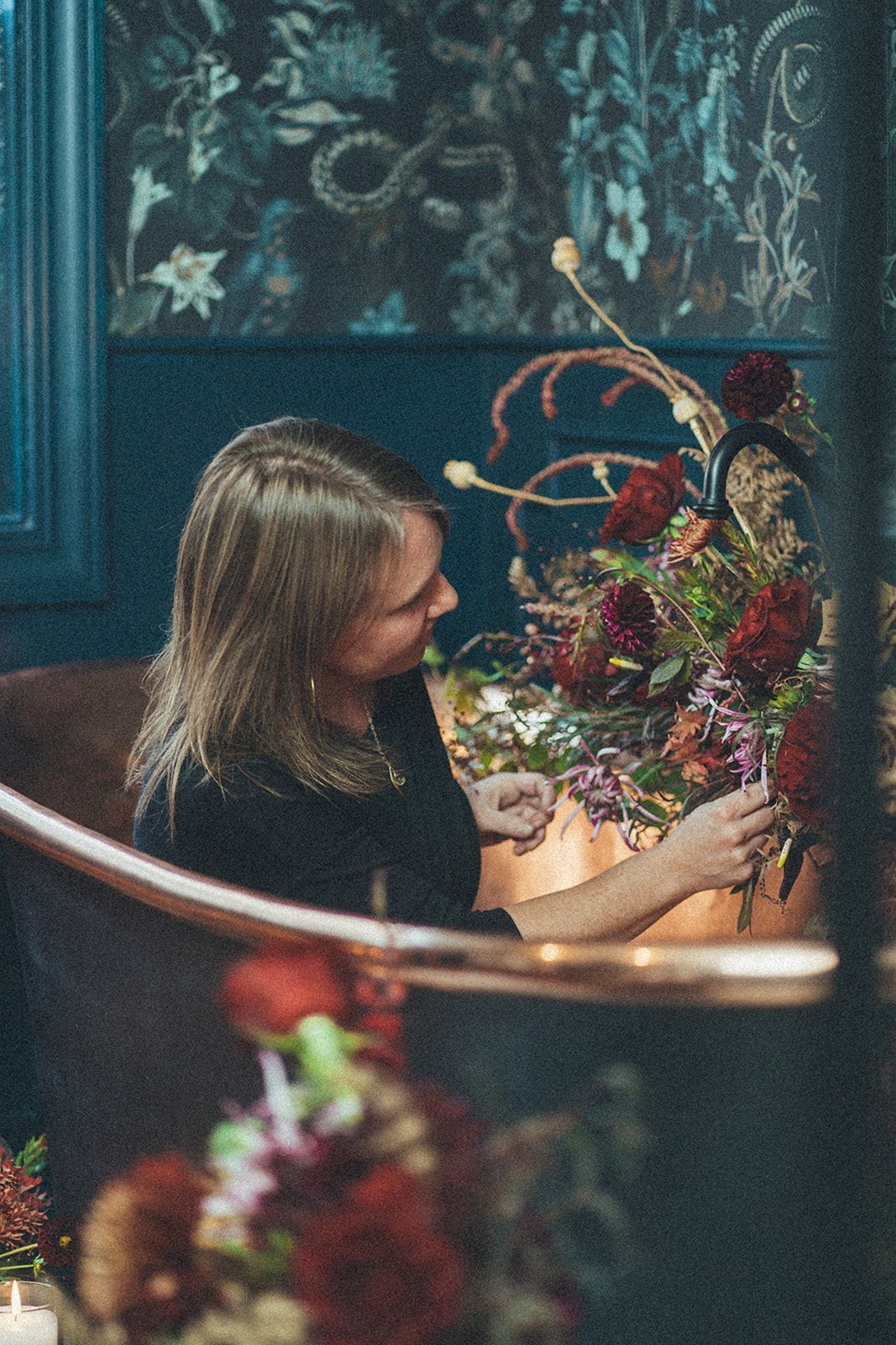 A woman is sitting at a table holding a bouquet of flowers.
