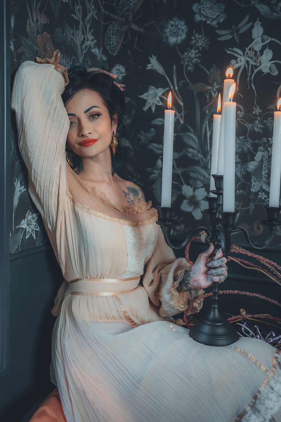 A woman in a white dress is sitting next to a candle holder.
