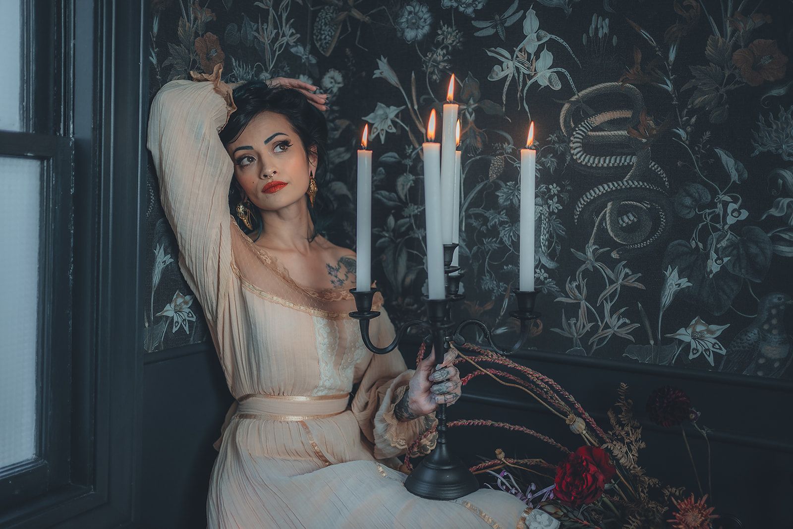 A woman in a white dress is sitting next to a candle holder.