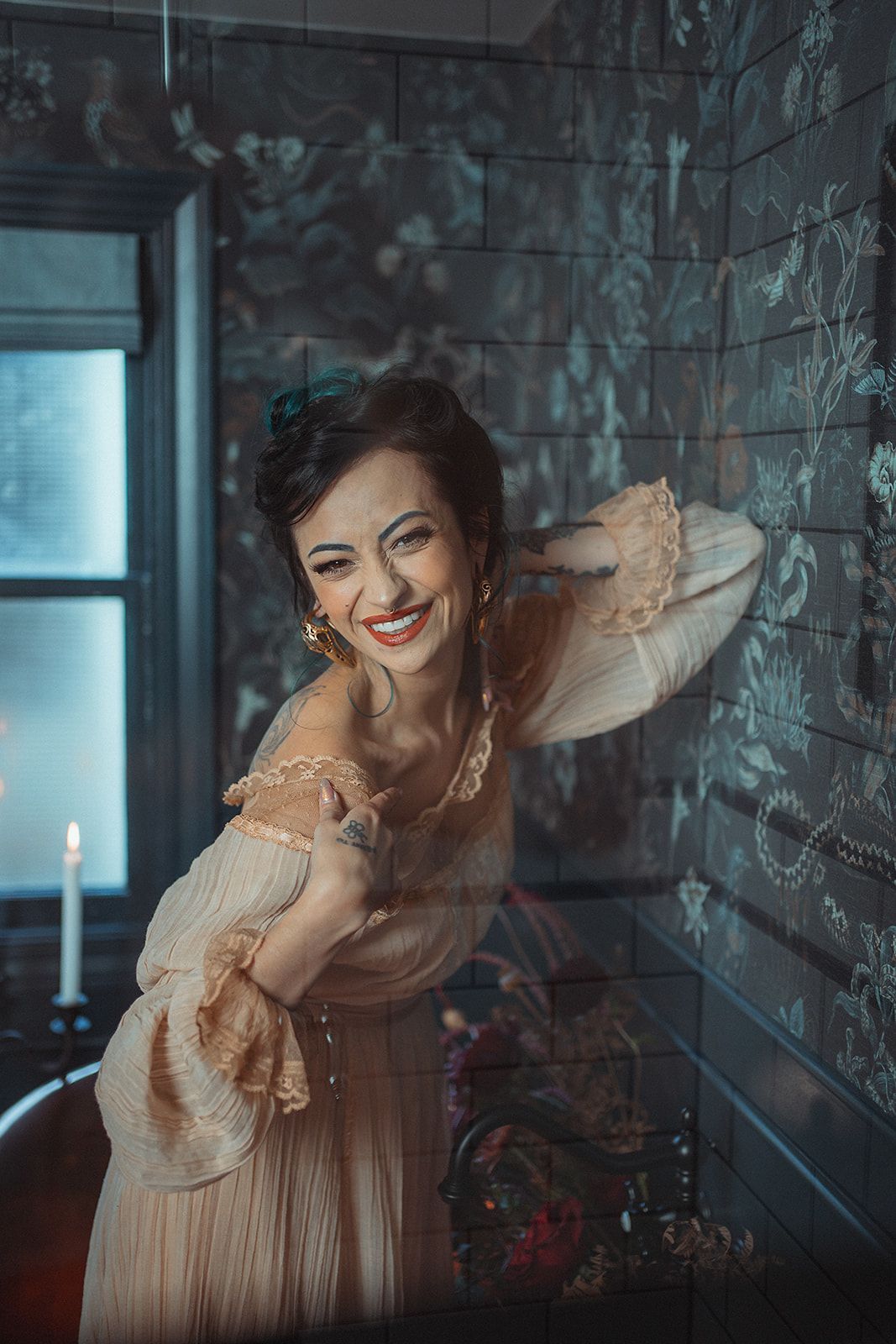 A woman in a dress is standing in front of a brick wall.
