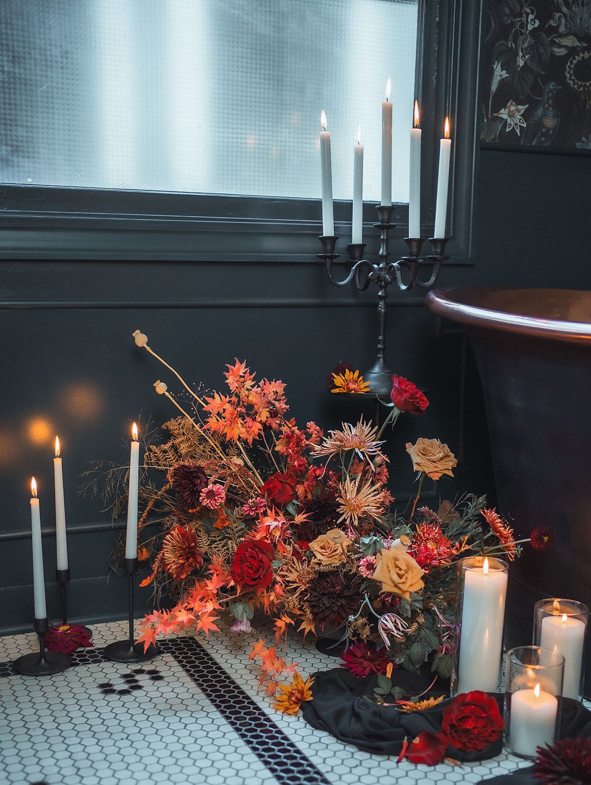 A bathroom decorated for halloween with candles and flowers.