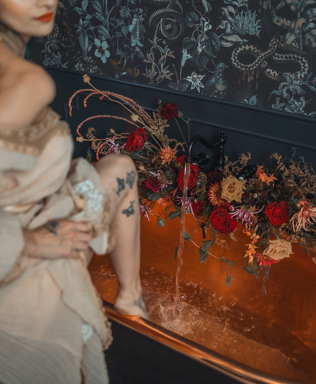 A woman is sitting in a bathtub filled with flowers.