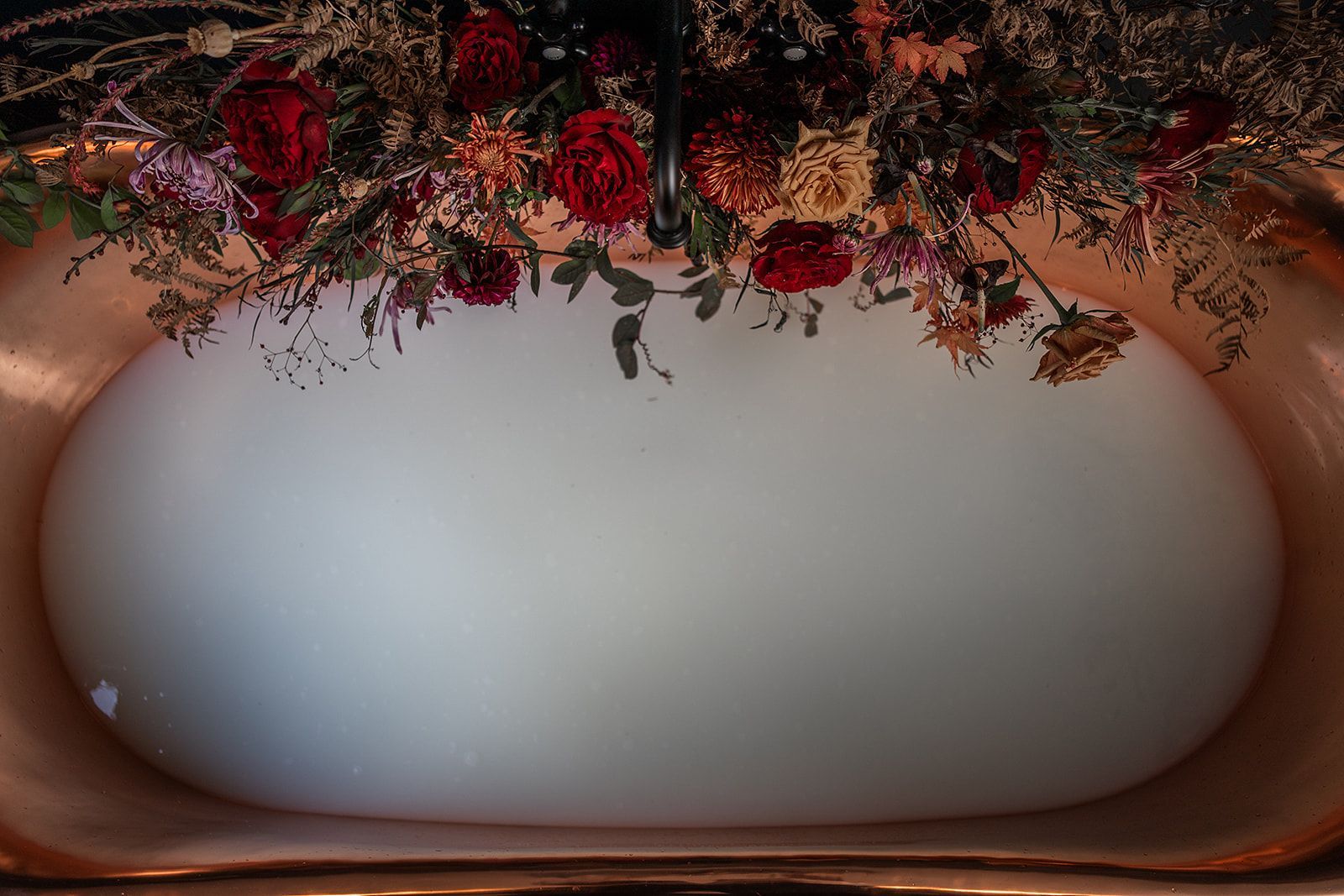 A white soap dish with flowers on top of it.