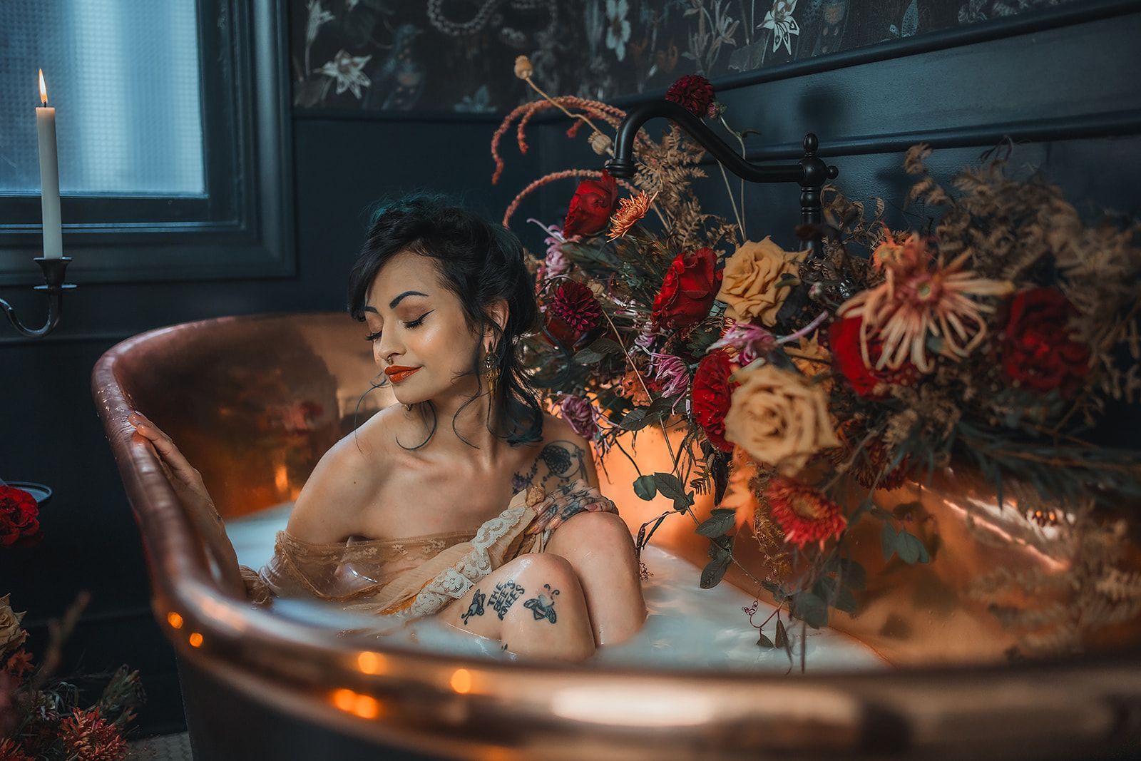 A woman is taking a bath in a bathtub filled with flowers and candles.