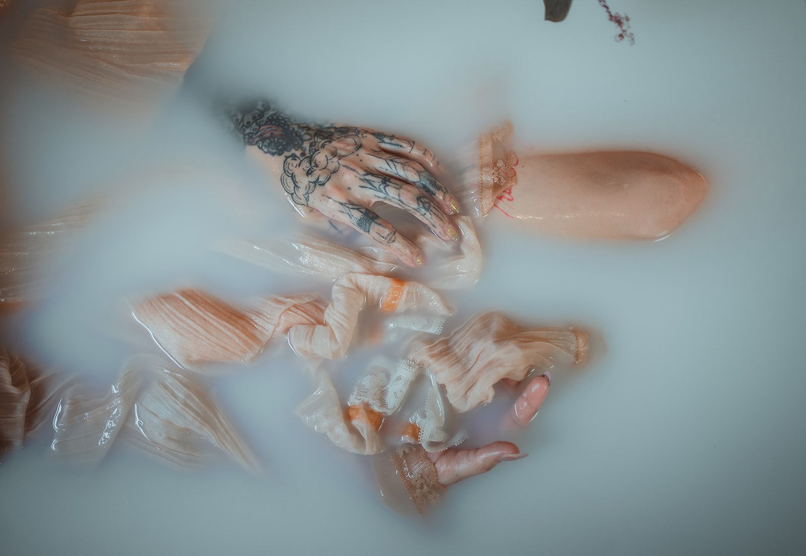 A woman is taking a bath in a bathtub filled with milk.