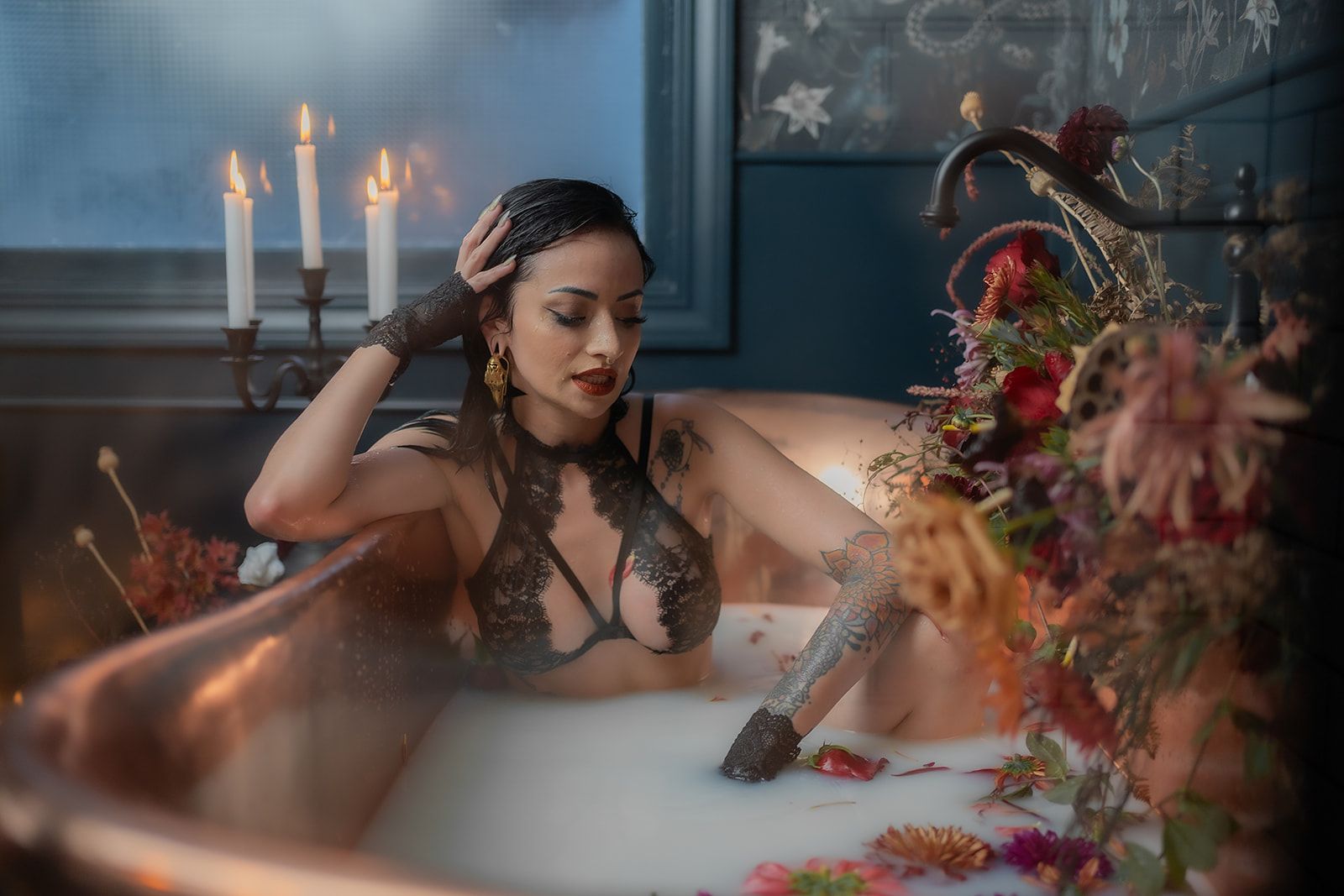 A woman is taking a bath in a bathtub filled with milk and flowers.