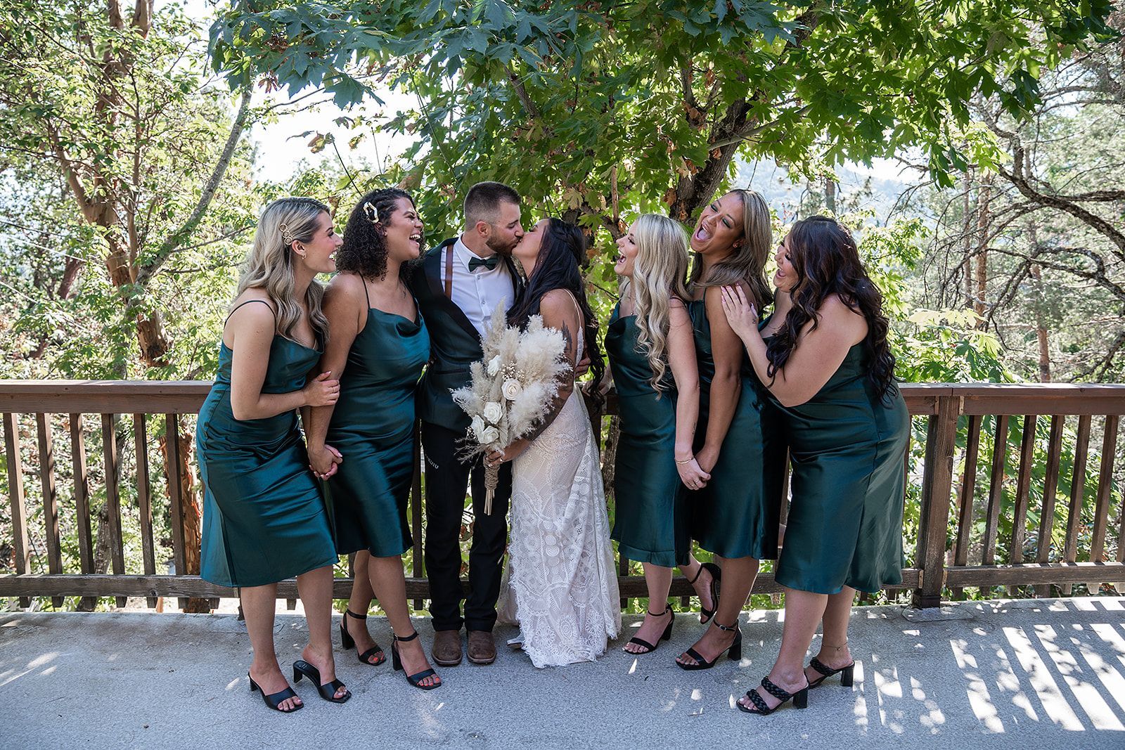 A bride and groom are posing for a picture with their bridesmaids.
