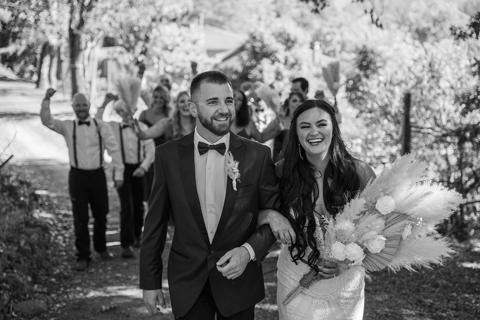 A bride and groom are walking down the aisle with their wedding party.